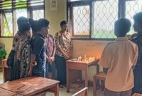 Wali Kelas dan teman-teman almarhum S. T. N (Noni) tengah menyalakan lilin dan berdoa mengenang almarhum Noni. 