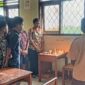 Wali Kelas dan teman-teman almarhum S. T. N (Noni) tengah menyalakan lilin dan berdoa mengenang almarhum Noni. 