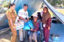 Lurah Beru, Elisabeth Neni Trinita bersama Ketua LPM Kelurahan Beru, Ruben Soludale menyerahkan bantuan kepada Mama Rosmini, penyitas gempa yang lakukan evakuasi mandiri di Lapangan Kota Baru Maumere
