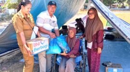 Lurah Beru, Elisabeth Neni Trinita bersama Ketua LPM Kelurahan Beru, Ruben Soludale menyerahkan bantuan kepada Mama Rosmini, penyitas gempa yang lakukan evakuasi mandiri di Lapangan Kota Baru Maumere