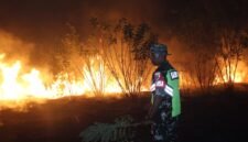 Keterangan foto: Babinsa Kopka Yoseph Win Benny dan seorang warga memadamkan api yang membakar lahan dengan peralatan seadannya, Kamis (27/8/2026) malam.